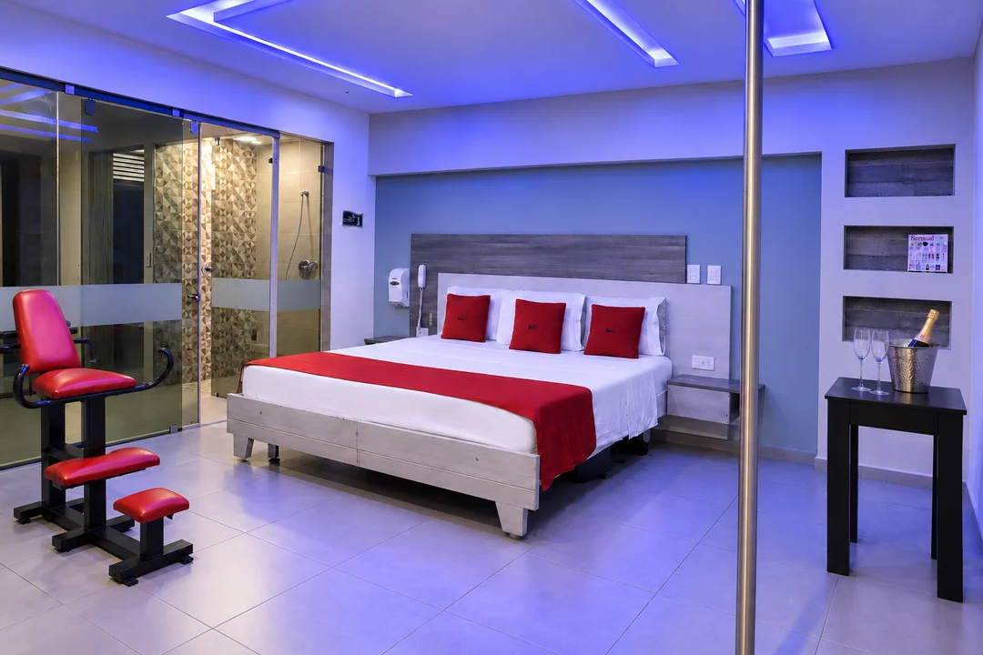 Habitación con jacuzzi: luz azul, cama amplia y baño de vidrio